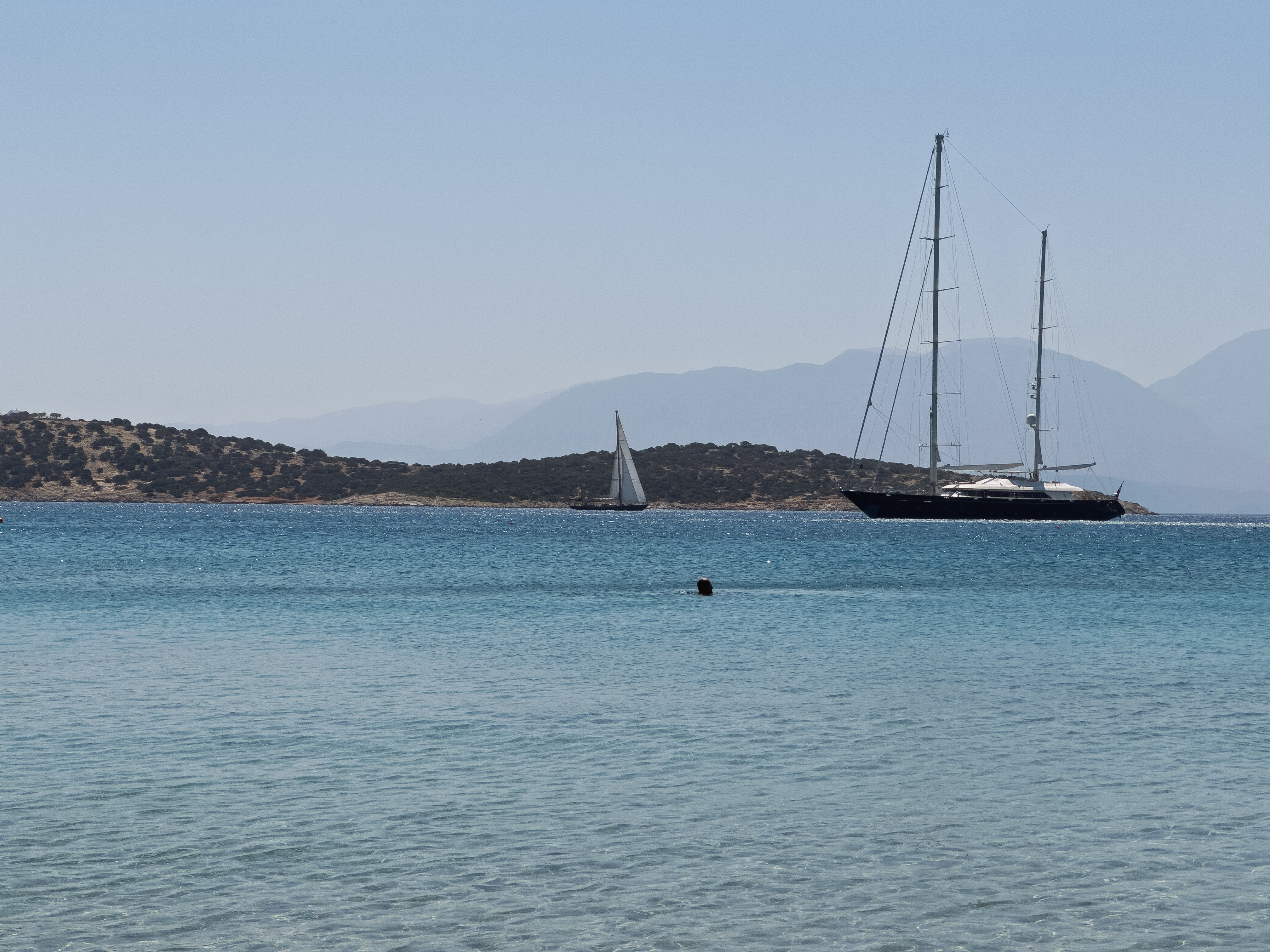 Sailboats on clear blue waters near Minos Beach Art Hotel, Crete.