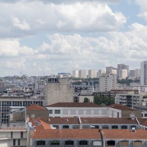 Cityscape with apartment buildings under a cloudy sky.